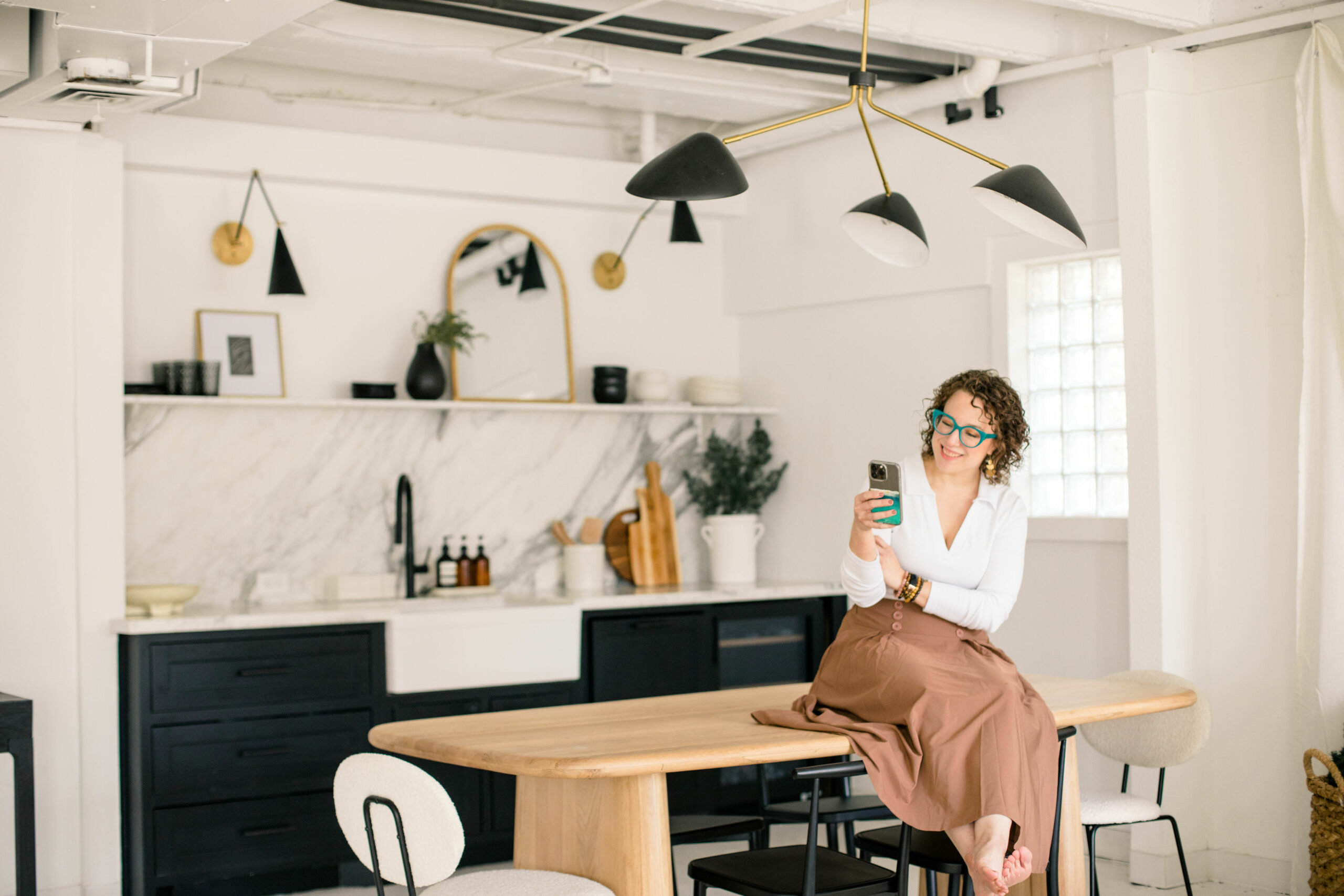 abundance life coaching - coach sitting on table on phone