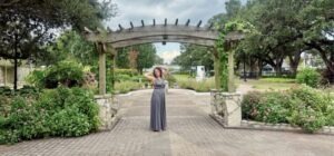 photo of alison reeves in a gray dress in a garden What Does Manifest Mean? A Real Definition